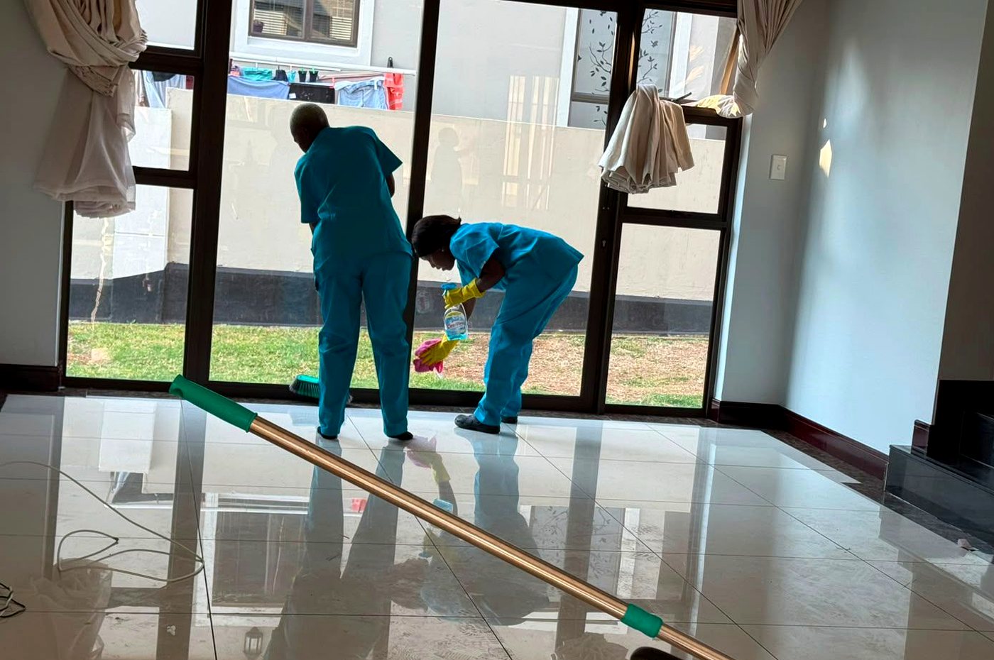 PrimeCare cleaners polishing floors and glass in a home